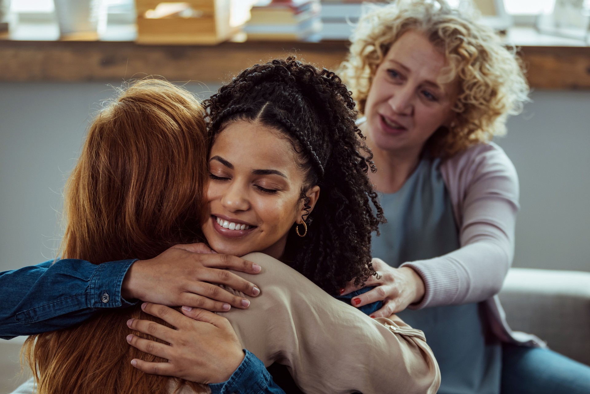 Two women hugging during a support group meeting