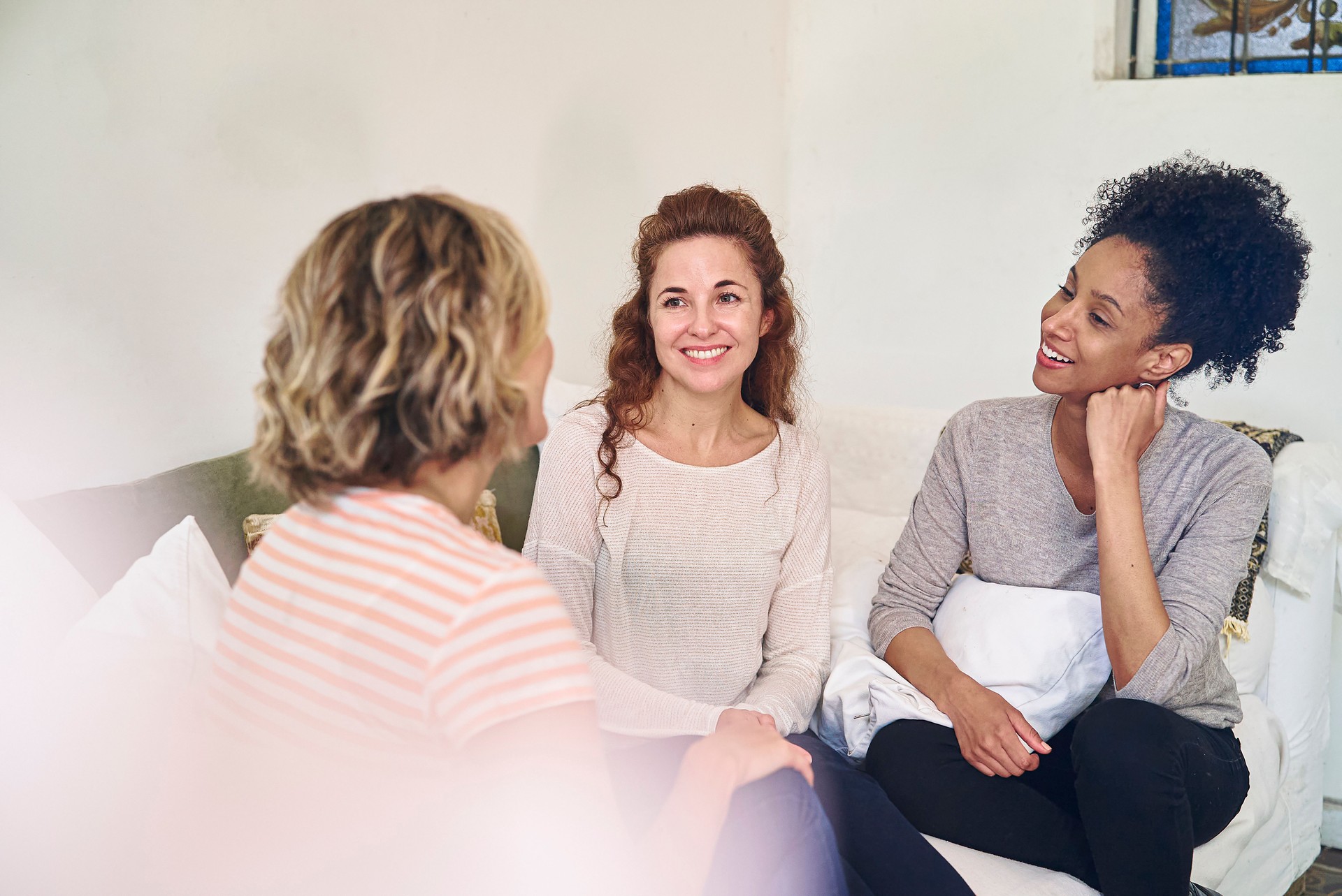 Female friends having a good conversation while sitting on couch